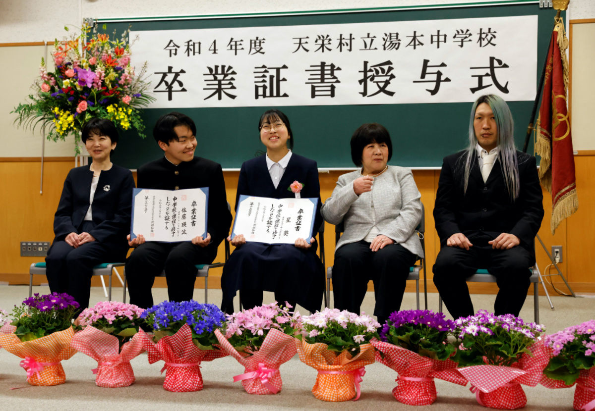 Eita Sato, 15, and Aoi Hoshi, 15, who are the only two students at Yumoto Junior High School, attend a photo session with their Eita's mother Masumi Sato, 46, and Aoi's grandmother Hisako, 68, and father Kazuhisa, 37, after the students' graduation and the institution's closing ceremony, in Ten-ei Village, Fukushima Prefecture, Japan, on 13th March 2023.