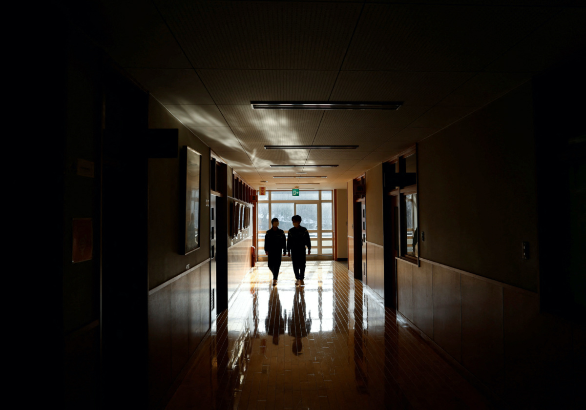 Eita Sato, 15, and Aoi Hoshi, 15, walk along the corridors of Yumoto Junior High School, where they are the only two students, a few days before their graduation and the institution's closing ceremony, in Ten-ei Village, Fukushima Prefecture, Japan, on 9th March, 2023. 