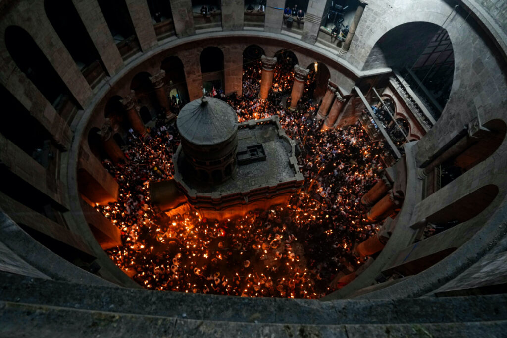 Christian pilgrims hold candles as they gather during the ceremony of the Holy Fire at Church of the Holy Sepulchre, where many Christians believe Jesus was crucified, buried and rose from the dead, in the Old City of Jerusalem, on Saturday, 23rd April, 2022.