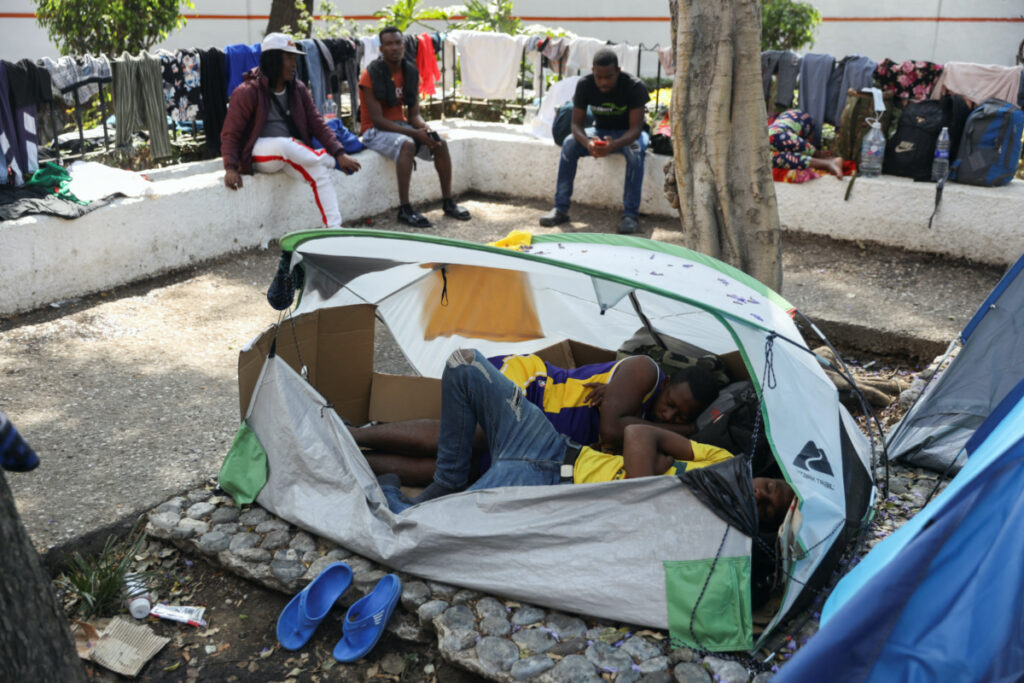 Migrants from Haiti sleep inside a tent in the migrant camp as migrants, mostly from Haiti, gather at the Giordano Bruno park as they wait for a permit or Visitor Card for Humanitarian Reasons that would allow them to continue their journey to the border between Mexico and the United States, in Mexico City, Mexico, on 30th March, 2023.