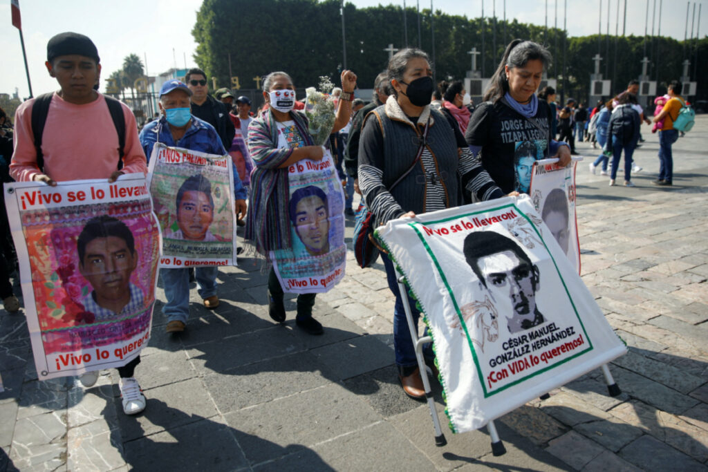 Relatives of missing students hold posters with their images as they arrive for a mass to mark the disappearance of the 43 Ayotzinapa College Raul Isidro Burgos students in the state of Guerrero, at the Basilica of Our Lady of Guadalupe in Mexico City, Mexico, on 26th December, 2022.