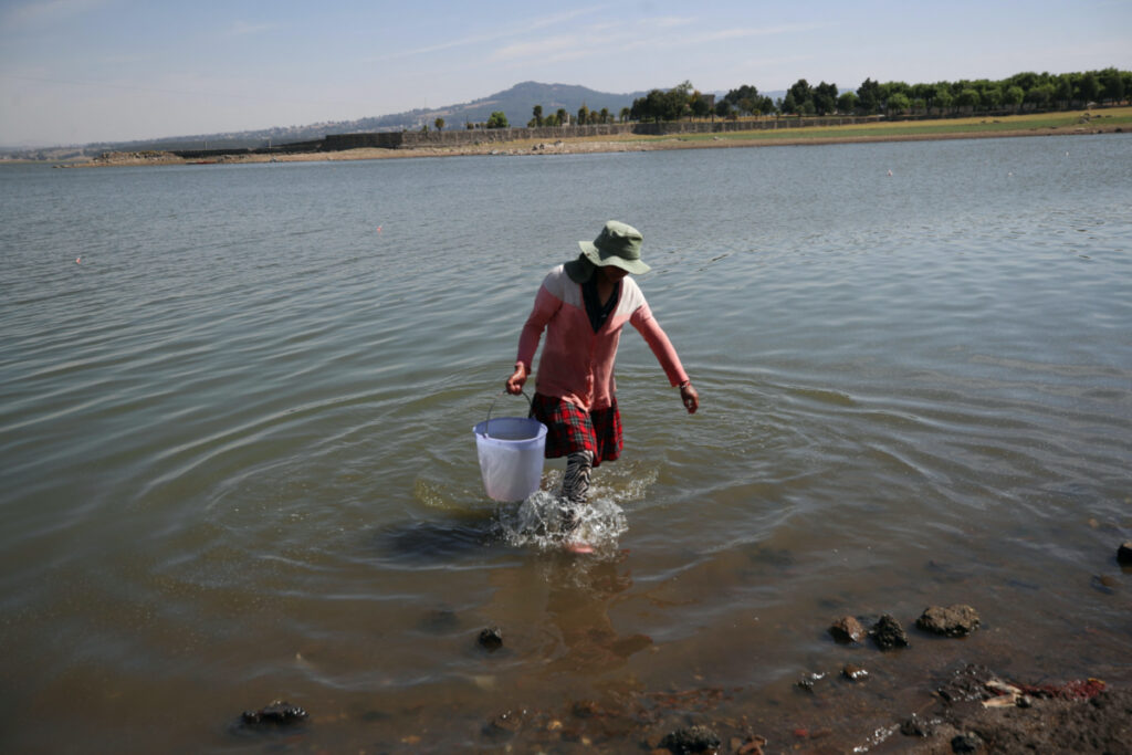 Gabriela Gonzalez, 22, walks after filling a plastic bucket with water to take home, on the shore of Villa Victoria Dam, part of the Cutzamala System collecting water for distribution into Mexico City and the metropolitan areas, in Villa Victoria, Mexico, on 26th April, 2023