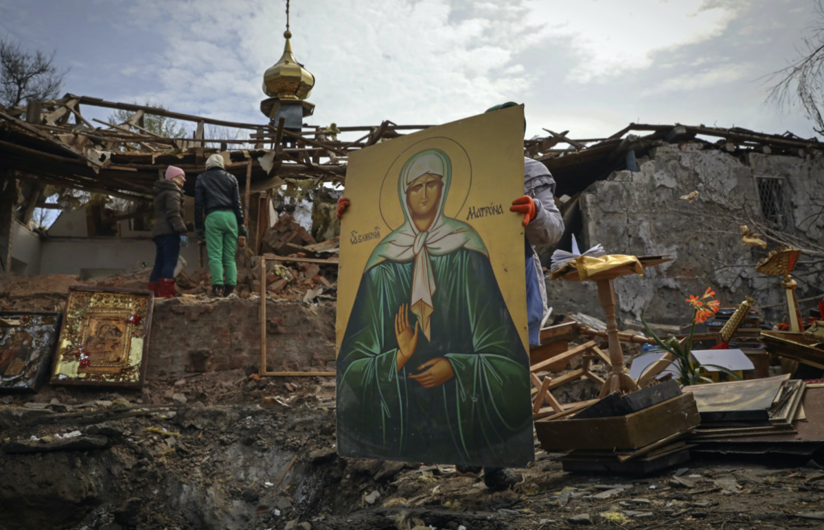 People save icons as they clear the rubble after a Russian rocket ruined an Orthodox church in rocket attack on Easter night, a crater left by the rocket in the foreground, in Komyshuvakha, Zaporizhzhia region, Ukraine, early hours of Sunday, 16th April, 2023.