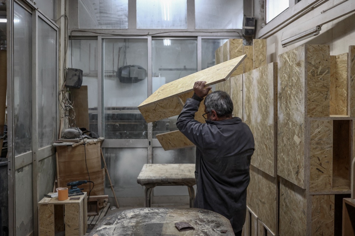 Prisoner Manuel Dias carries a bench in the carpentry workshop of Custoias Prison in Porto, Portugal, on 14th April, 2023.