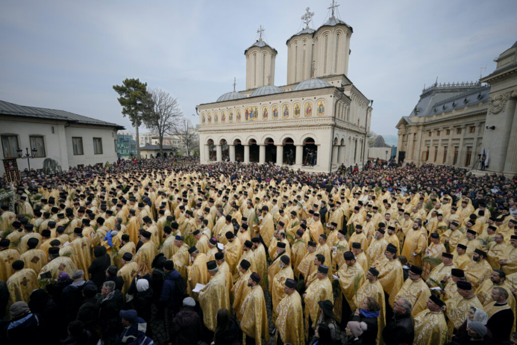 Romanian Orthodox priests and believers stand outside the Patriarchal Cathedral after an Orthodox Palm Sunday pilgrimage in Bucharest, Romania, on Saturday, 8th April 2023.
