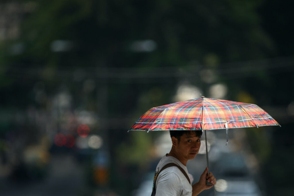 A man holds up an umbrella as temperatures hit a record 45.4 degrees Celsius in Bangkok, Thailand, on 21st April, 2023.