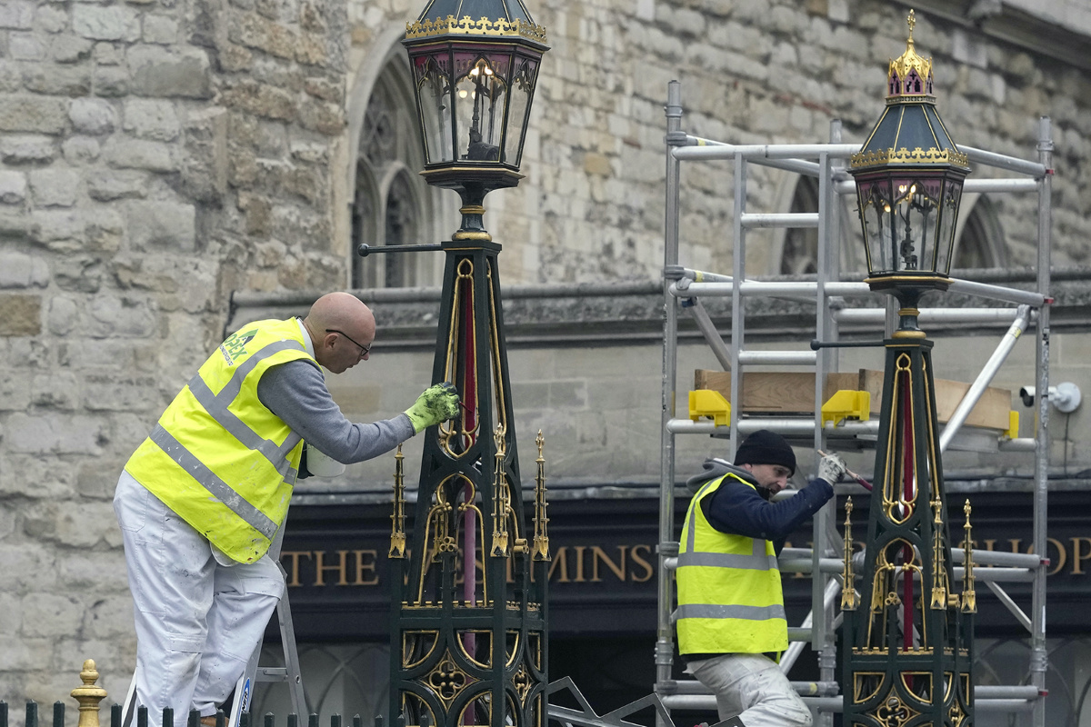 Painters repaint the lamp posts outside Westminster Abbey as preparations continue for the Coronation of King Charles III in London, Britain, Thursday, on 27th April, 2023. 