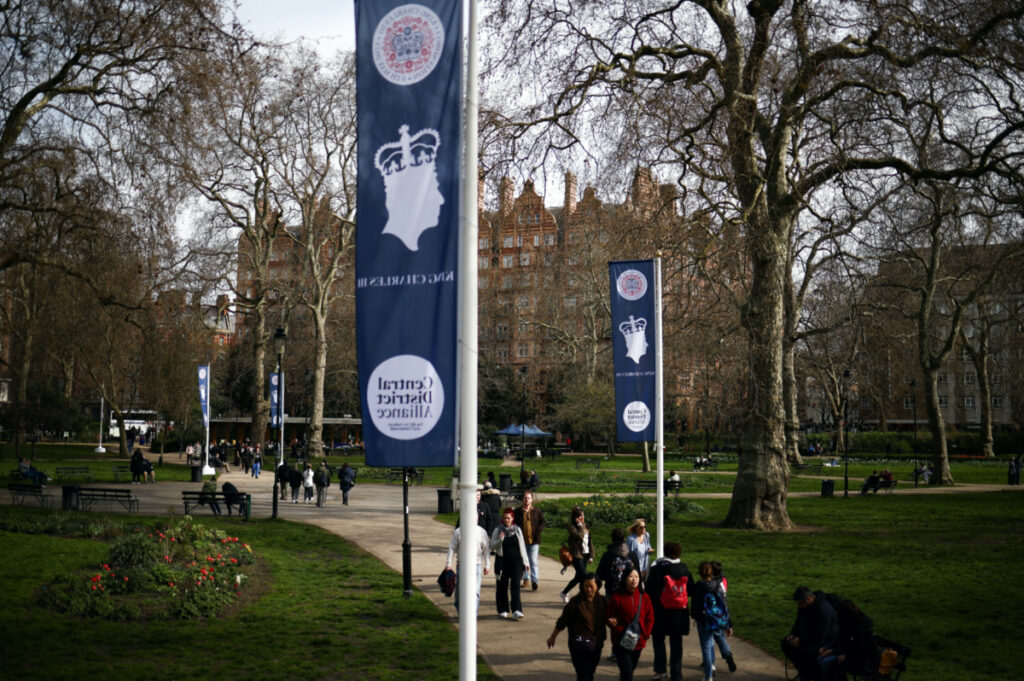 People walk underneath flags celebrating the upcoming Coronation of Britain’s King Charles III in central London, Britain, on 8th April, 2023.