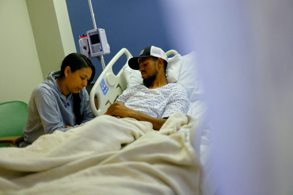 Eduard Caraballo, a Venezuelan migrant who was injured after a fire broke out last week at an immigration detention centre in Ciudad Juarez, Mexico, is visited by his wife Viangly Infante at a hospital in El Paso, Texas, US, on 3rd April, 2023.