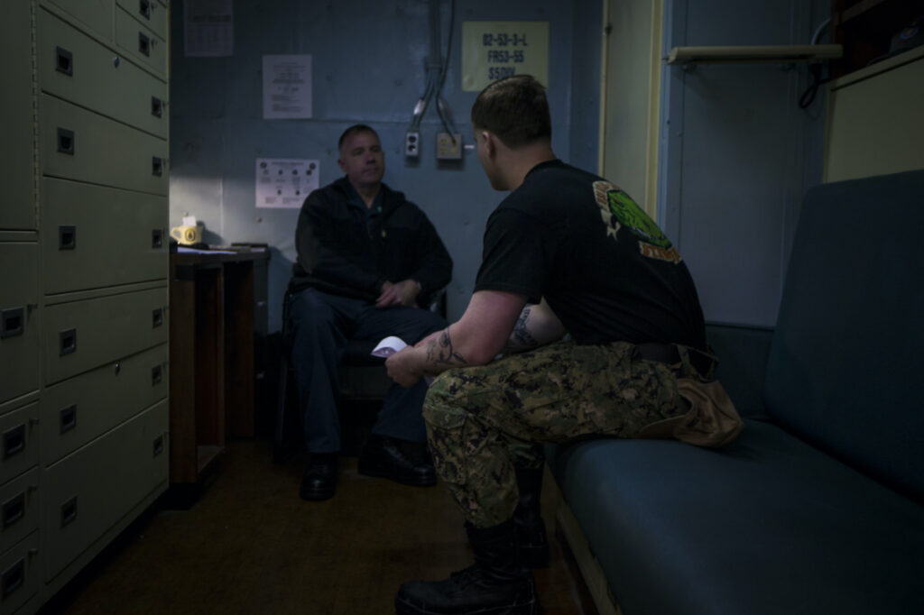 Navy Chaplain Lt Cmdr Ben Garrett counsels a sailor in his quarters on the USS Bataan on Monday, 20th March, 2023 at Norfolk Naval Station in Norfolk, Virginia