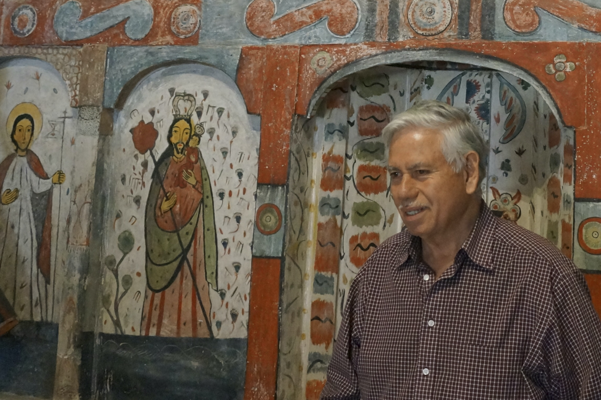 Master santero Felix Lopez – an artist trained in New Mexico's centuries-old tradition of religious sculpture and painting – stands in front of the 1810s reredo or altarpiece he cleaned and preserved in the Holy Rosary Mission Church in Truchas, New Mexico, Sunday, April 16, 2023. To his right is a painting of St. Joseph, a popular saint in these remote villages that have kept the Catholic faith first brought by Spanish missionaries in the 17th century and now fight to preserve the churches as population, and congregations, dwindle. (AP Photo/Giovanna Dell'O