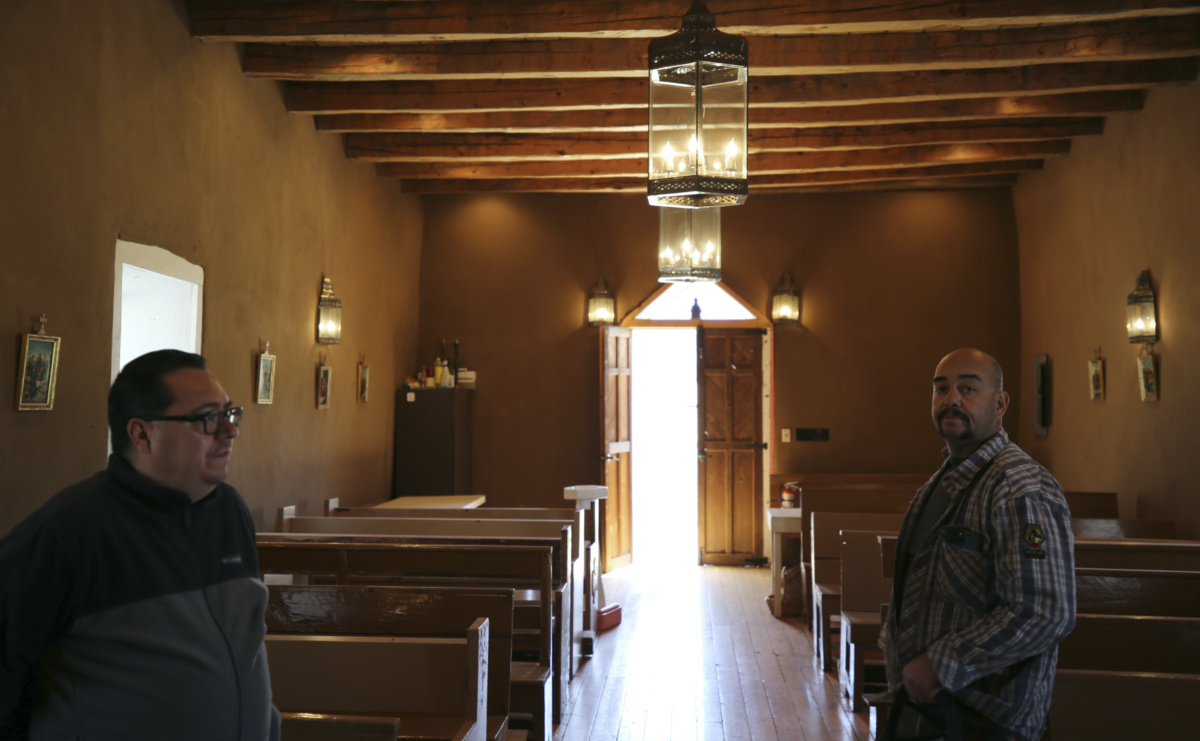 Fidel Trujillo, left, and Leo Paul Pacheco, stand inside the 1880s Santo Niño de Atocha chapel in Monte Aplanado, New Mexico, on Saturday, 15th April 2023