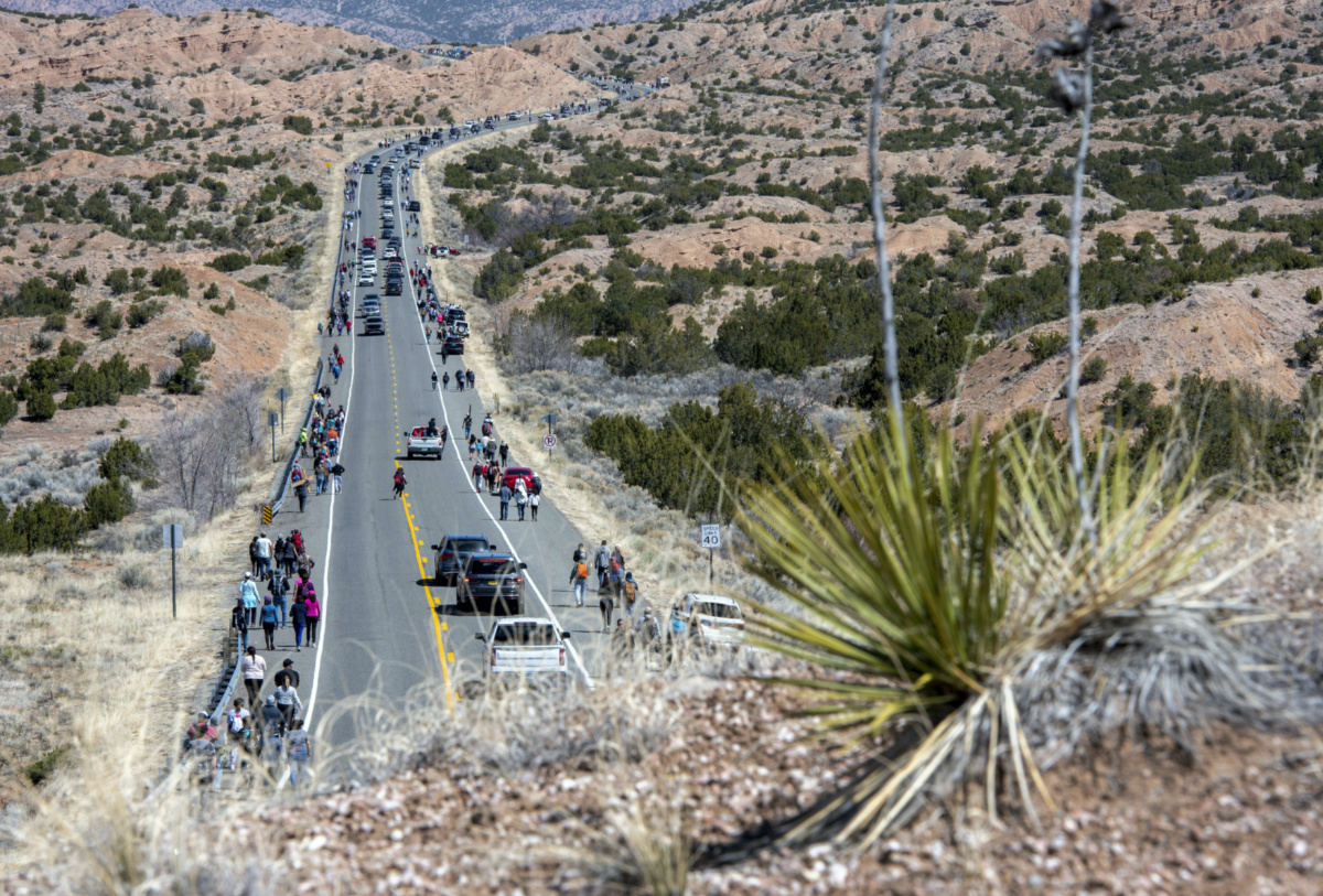 People walk and drive along Santa Fe County Road 98 to get to the Santuario de Chimayo during a Good Friday pilgrimage, on Friday, 7th April