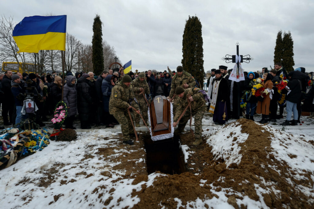 Ukrainian servicemen lower to grave a coffin with the body of their brother-in-arms Volodymyr Androshchuk, who was recently killed in a fight against Russian troops near the Bakhmut town, amid Russia's attack on Ukraine, during a funeral ceremony at a cemetery in the town of Letychiv, Khmelnytskyi region, Ukraine, on 1st February, 2023.
