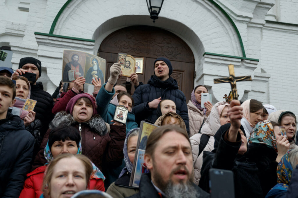 FILE PHOTO: Believers of the Ukrainian Orthodox Church, accused of being linked to Moscow, pray while they block an entrance to a church at a compound of the Kyiv Pechersk Lavra monastery, amid Russia's attack on Ukraine, in Kyiv, Ukraine March 31, 2023. REUTERS/Valentyn Ogirenko/File Photo