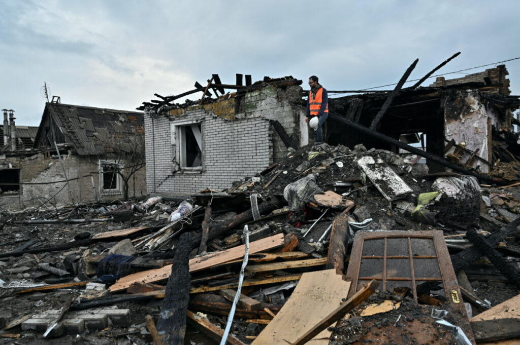 A volunteer inspects remains of a residential house damaged by a Russian missile strike in Zaporizhzhia, Ukraine, on 9th April, 2023.