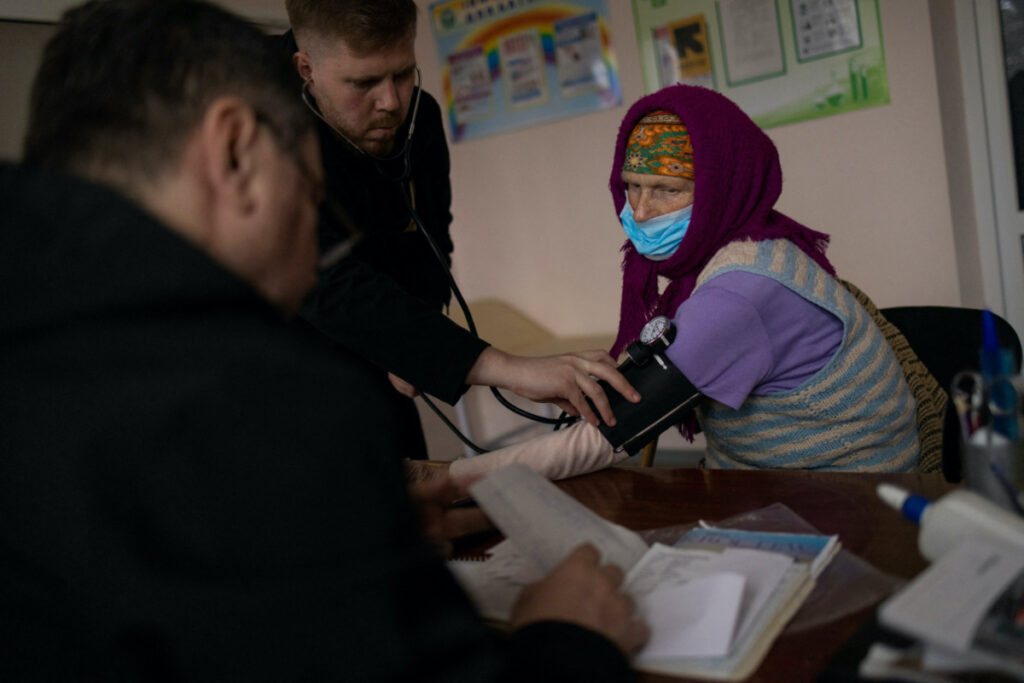 Doctor Oleg Marchenko examines a local resident at a clinic in the liberated village of Vyshneva, near Kharkiv in eastern Ukraine, on 21st April, 2023
