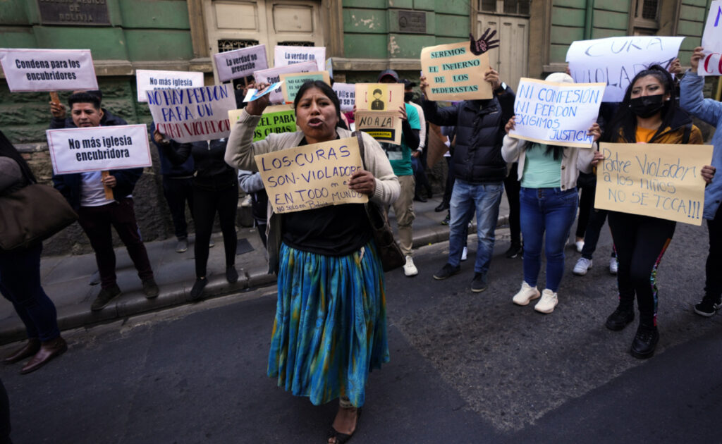 People protest with signs, one reading in Spanish "Priests are rapists all over the world, not just in Bolivia" centre, outside the Bolivian Archbishopric office in La Paz, Bolivia, on Friday, 19th May, 2023.