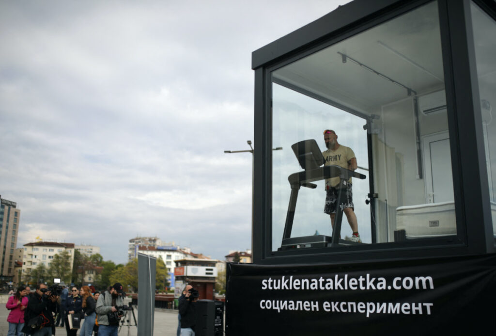 Bulgarian ultramarathon runner Krasse Gueorguiev exercises on a treadmill as he self-isolates inside a small glass cage for 15 days, as part of a social experiment aimed to raise donations to fund programs fighting addictions among young people, in Sofia, Bulgaria, on 30th April, 2023.