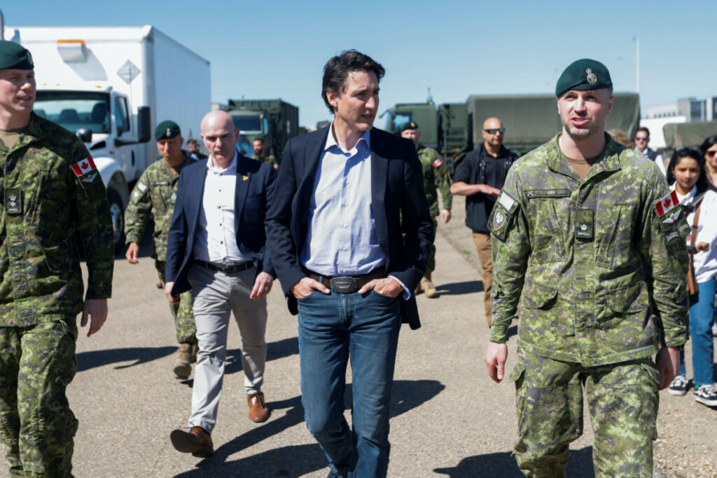 Canada's Prime Minister Justin Trudeau and Minister of Tourism Randy Boissonnault walk as they speak with Canadian Forces personnel at CFB Edmonton, who are assisting in wildfire relief efforts, in Sturgeon County, Alberta, Canada, on 15th May, 2023.