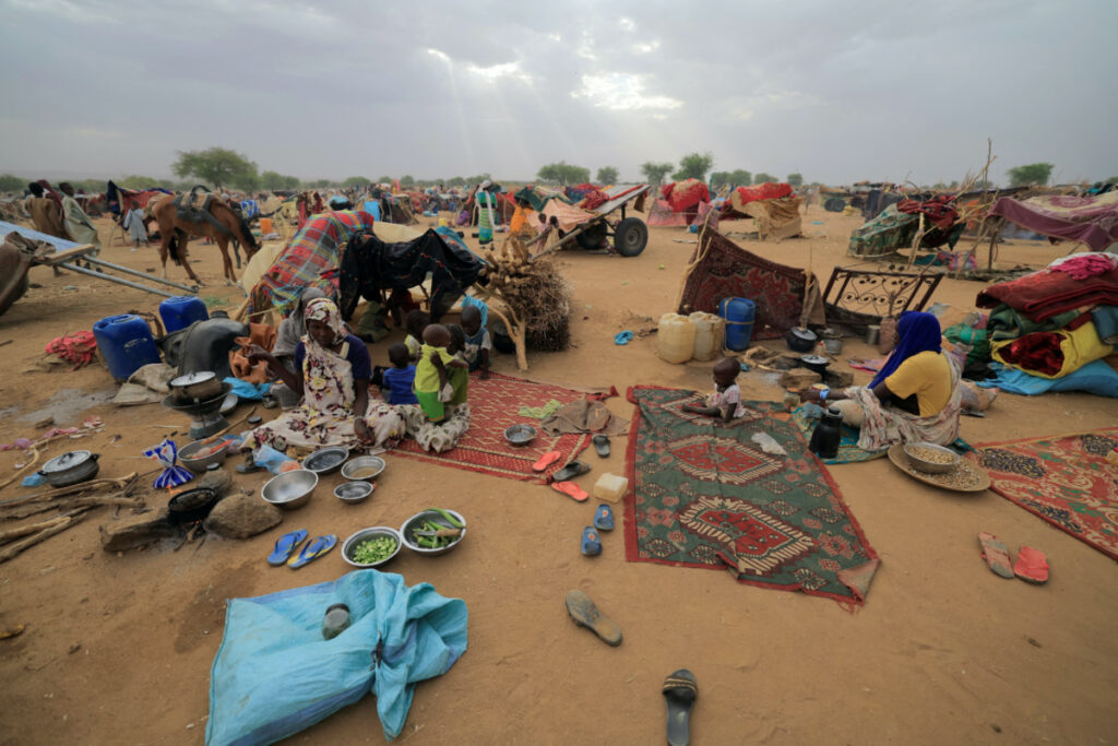 Sudanese refugee women who have fled the violence in Sudan's Darfur region, prepare breakfast beside their makeshift shelters near the border between Sudan and Chad in Koufroun, Chad, on 11th May, 2023.