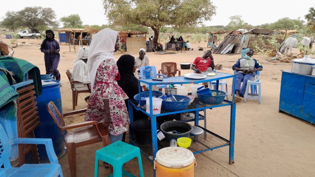 Fatma Dahab Ousman, a Sudanese refugee who fled the violence in her country, sells tea and porridge to other refugees near the border between Sudan and Chad, in Koufroun, Chad, on 1st May, 2023.