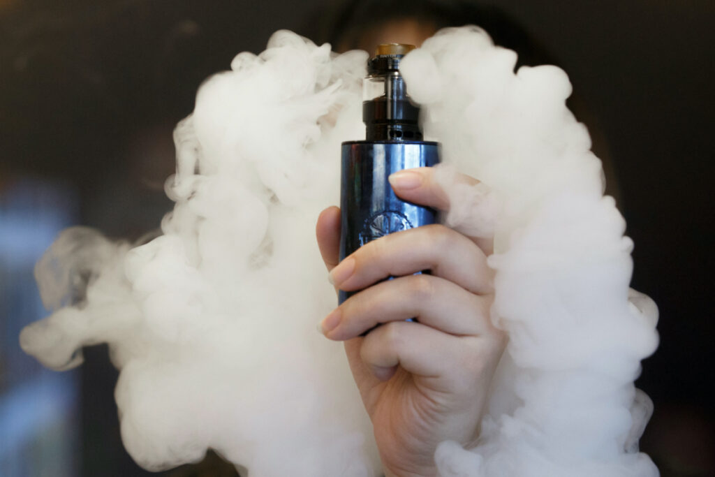A saleswoman holds an e-cigarette as she demonstrates vaping at the Vape Shop that sells e-cigarette products in Beijing, China, on 30th January, 2019