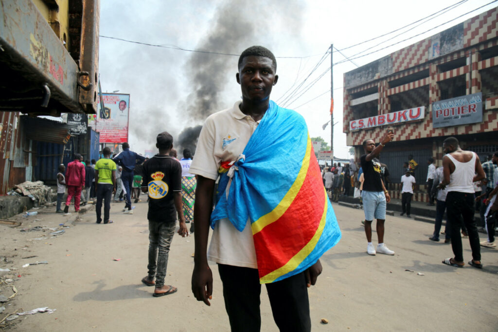 An anti-government demonstrator wears a Democratic Republic of Congo flag as he takes part in a riot, after security forces broke up an attempted demonstration organized by the opposition and civil society members over alleged irregularities in voter registration for the upcoming December elections, in Kinshasa, Democratic Republic of Congo, on 20th May, 2023.