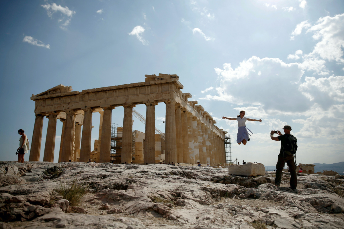 Tourists take a picture in front of the temple of the Parthenon atop the Acropolis in Athens, Greece, on 20th July, 2018.
