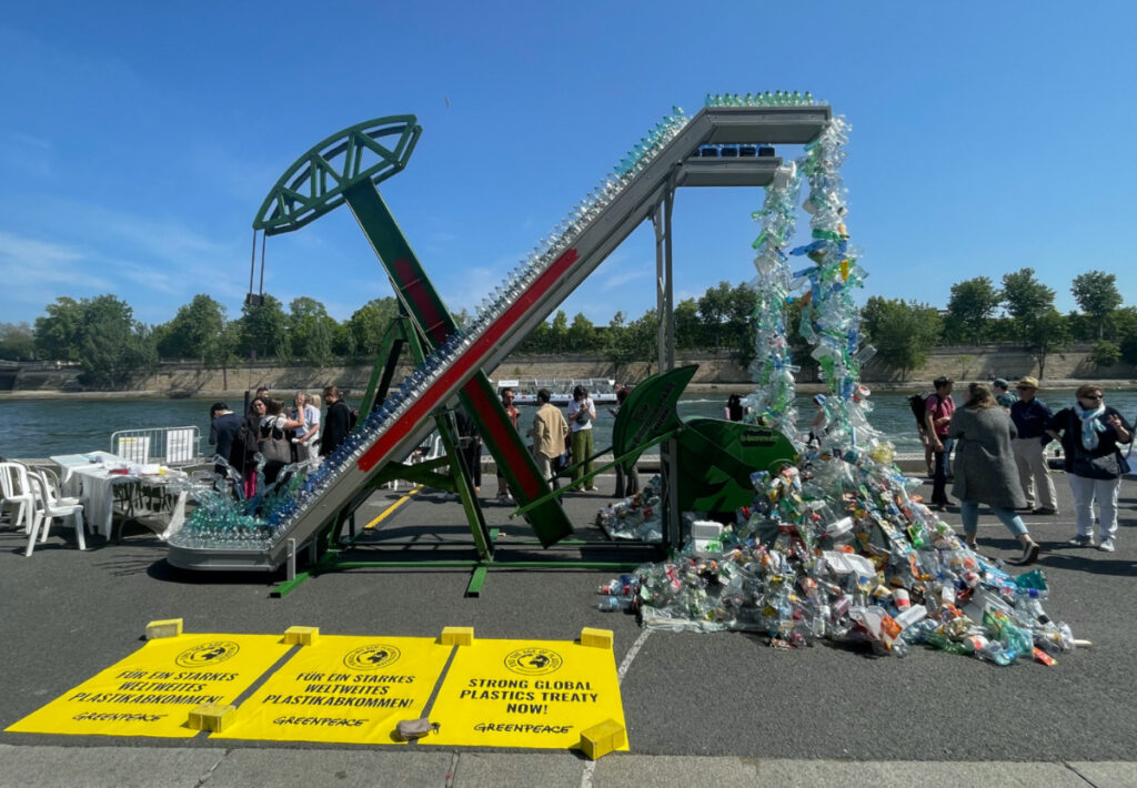 People stand next to artist Benjamin Von Wong's art installation unveiled by the Greenpeace International, ahead of a four-day summit of the United Nations Environment Programme on reducing plastic pollution, in Paris, France, on 27th May, 2023.
