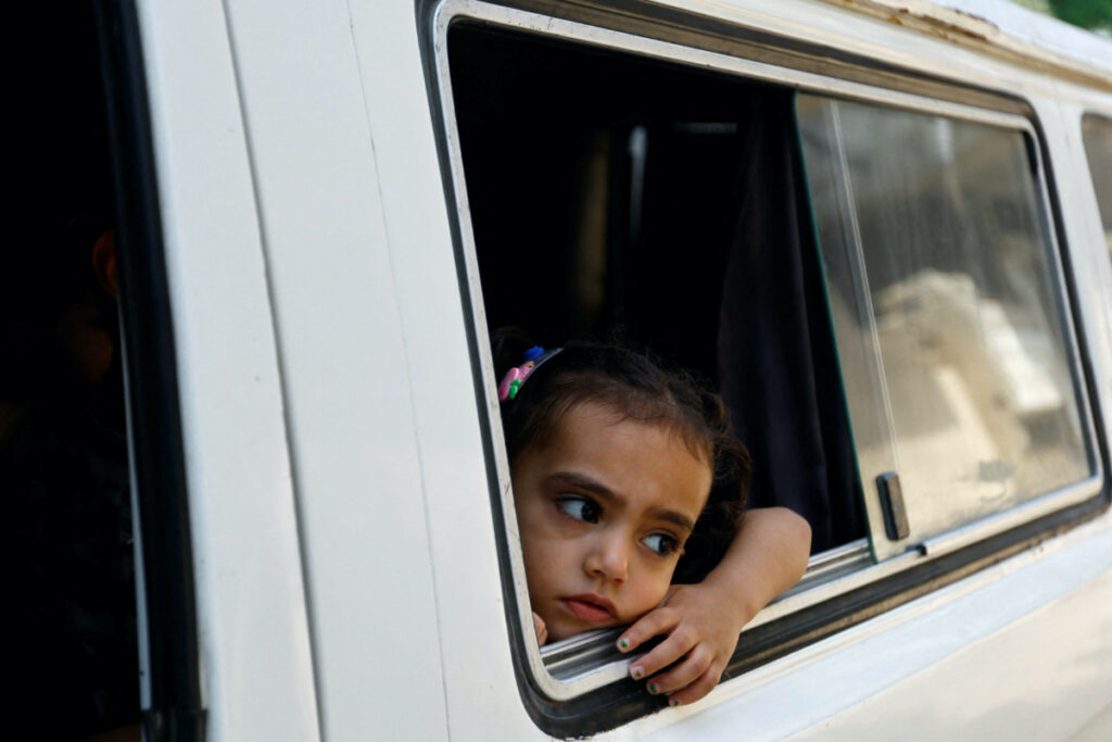 A Palestinian girl looks at a psychiatrist through an open van window, in Deir al-Balah, central Gaza Strip, on 16th May, 2023.