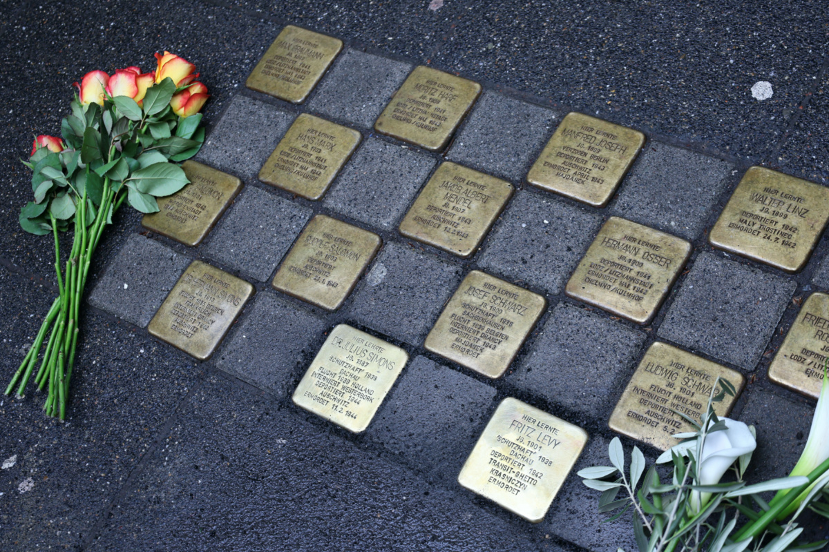 Flowers are placed next to Stumbling stones of artist Gunter Demnig following a stone laying ceremony for a former teacher and a former pupil of the Deutzer Gymnasium Schaurtestrasse in Cologne, Germany, on 8th March, 2023
