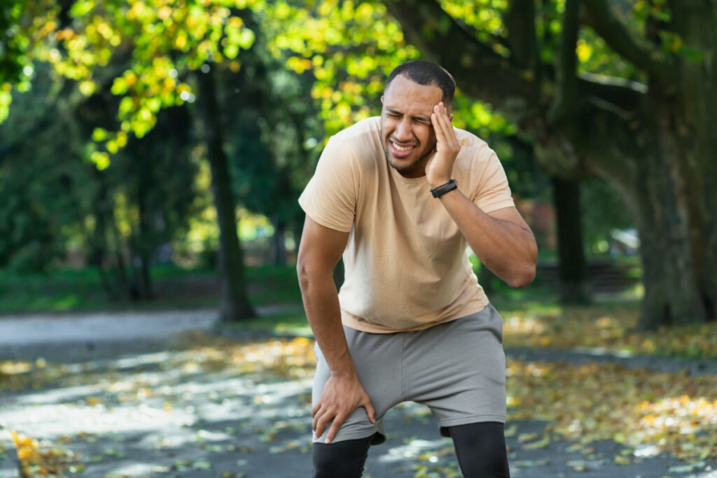Man after jogging in the park has a bad headache