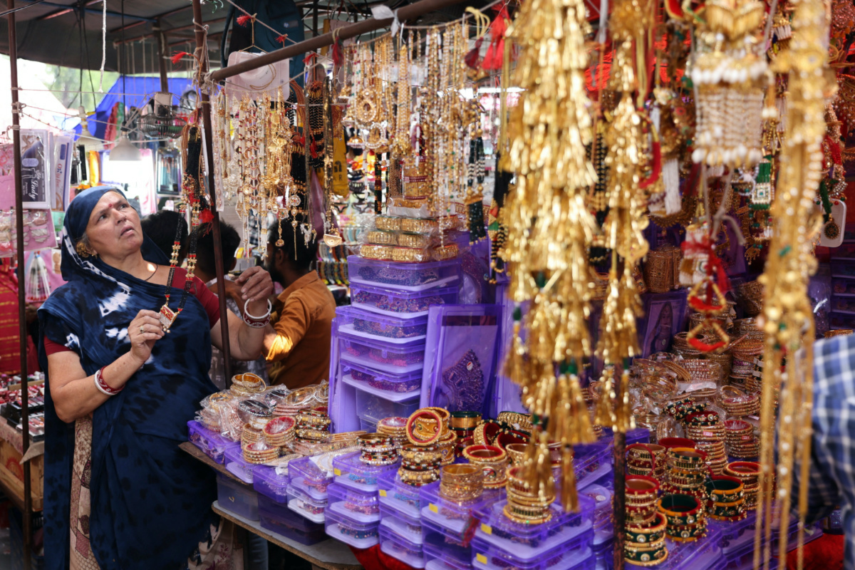 Kamlaben Ashokbhai Patni adjusts imitation jewellery at a stall in a market in Ahmedabad, India, on 30th April, 2023