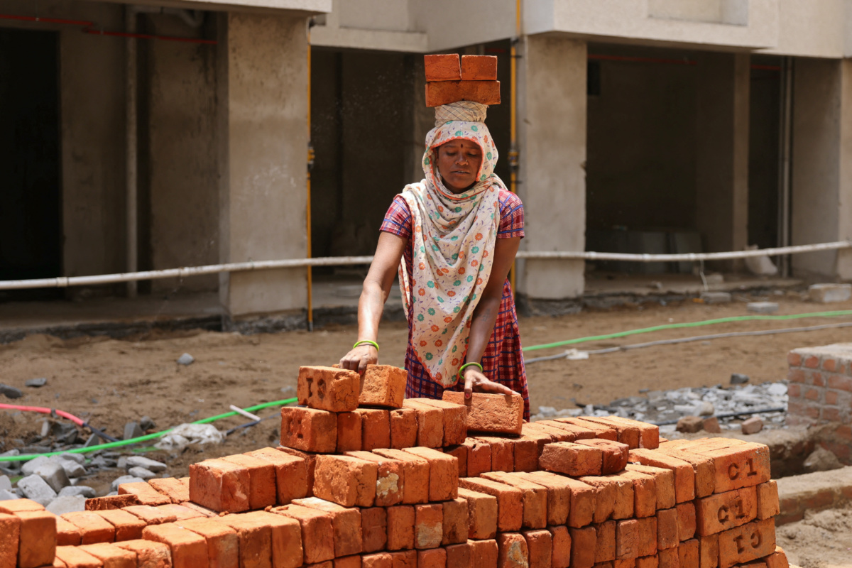 A woman carries bricks at a construction site in Ahmedabad, India, on 28th April, 2023.