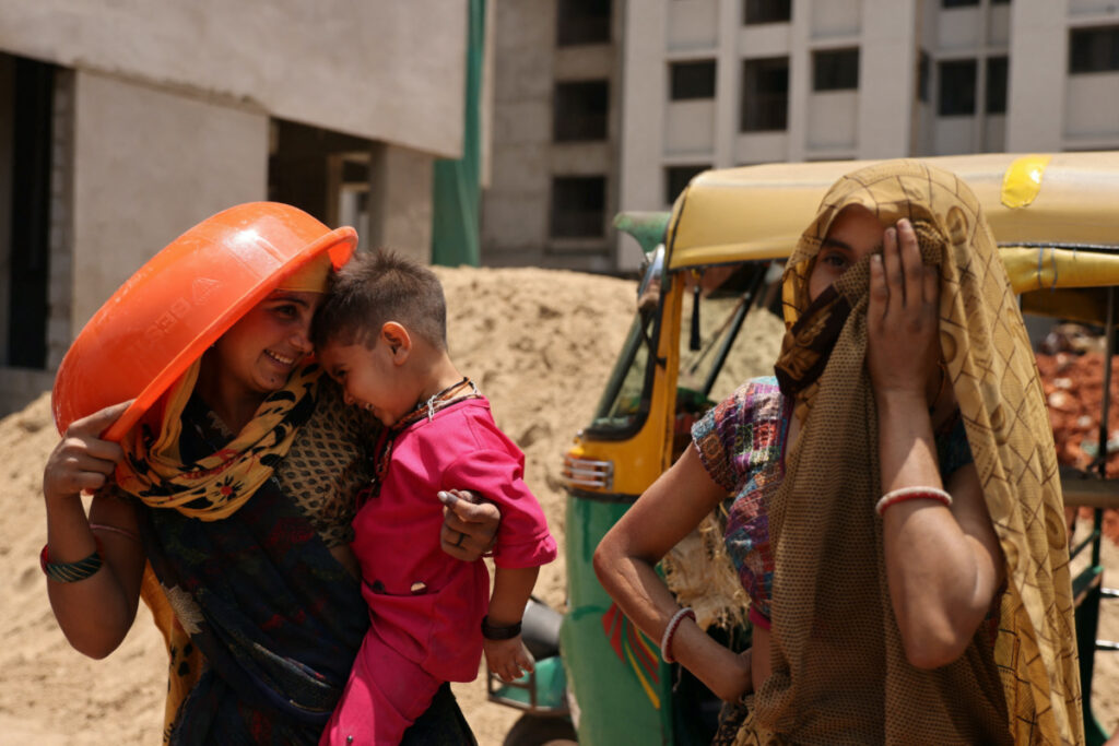 Women take shelter from the sun at a construction site in Ahmedabad, India, on 28th April, 2023.