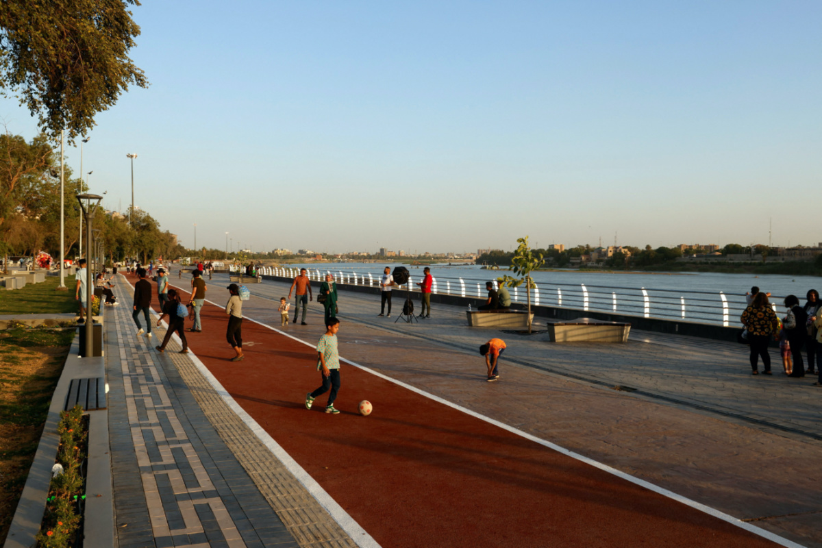 People walk at a promenade by the Tigris river and Abu Nawas park that has been partially opened to the public, in Baghdad, Iraq, on 14th May, 2023.