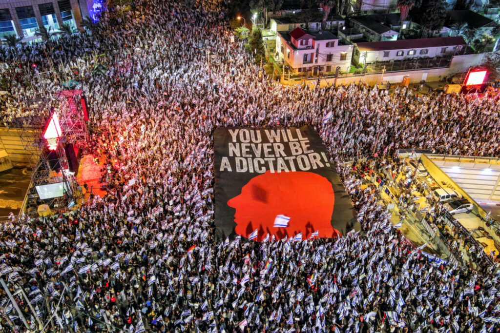 An aerial view shows protesters holding a sign with the silhouette of the face of Israeli Prime Minister Benjamin Netanyahu, as they take part in a demonstration against Israel's nationalist coalition government's judicial overhaul, in Tel Aviv, Israel May 6, 2023.