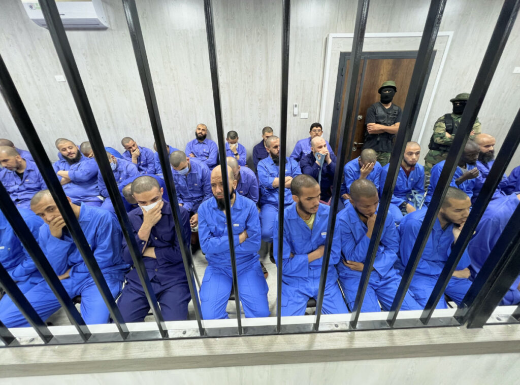 Suspects sit behind bars during a judgment sentence against 56 defendants accused of joining Islamic State group in the court in Misrata, Libya, on 29th May, 2023