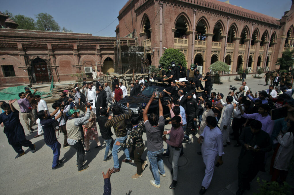 Members of the media film the vehicle carrying Pakistan's former Prime Minister Imran Khan and his wife Bushra Bibi as they arrive to appear at the High Court in Lahore, Pakistan, on 15th May, 2023.