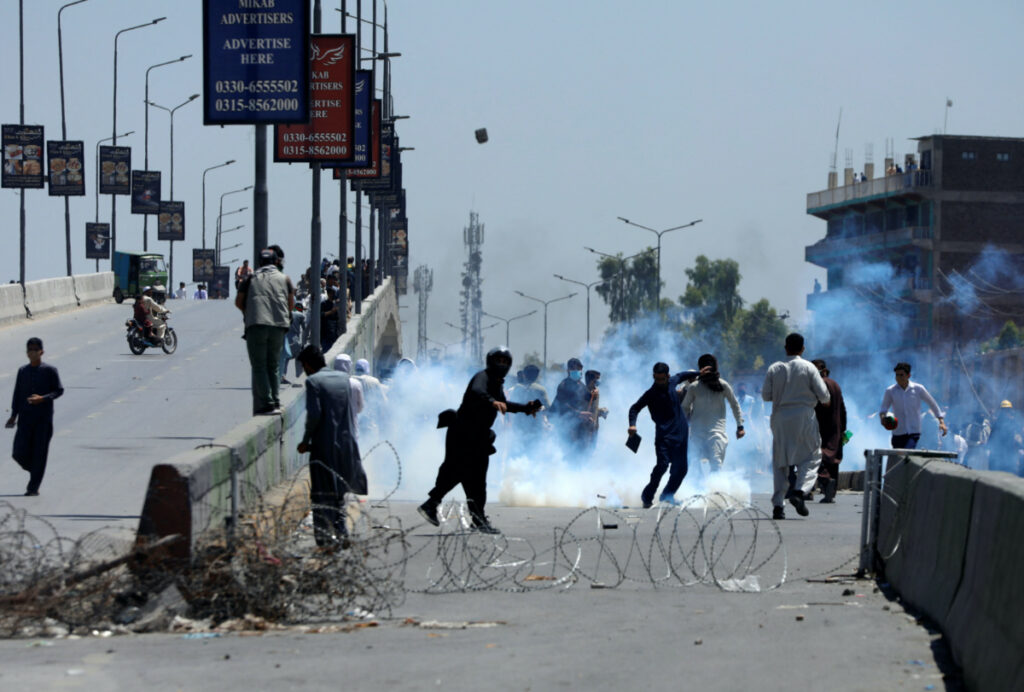 Supporters of Pakistan's former Prime Minister Imran Khan throw stones towards police during a protest against Khan's arrest, in Peshawar, Pakistan, on 10th May 2023.