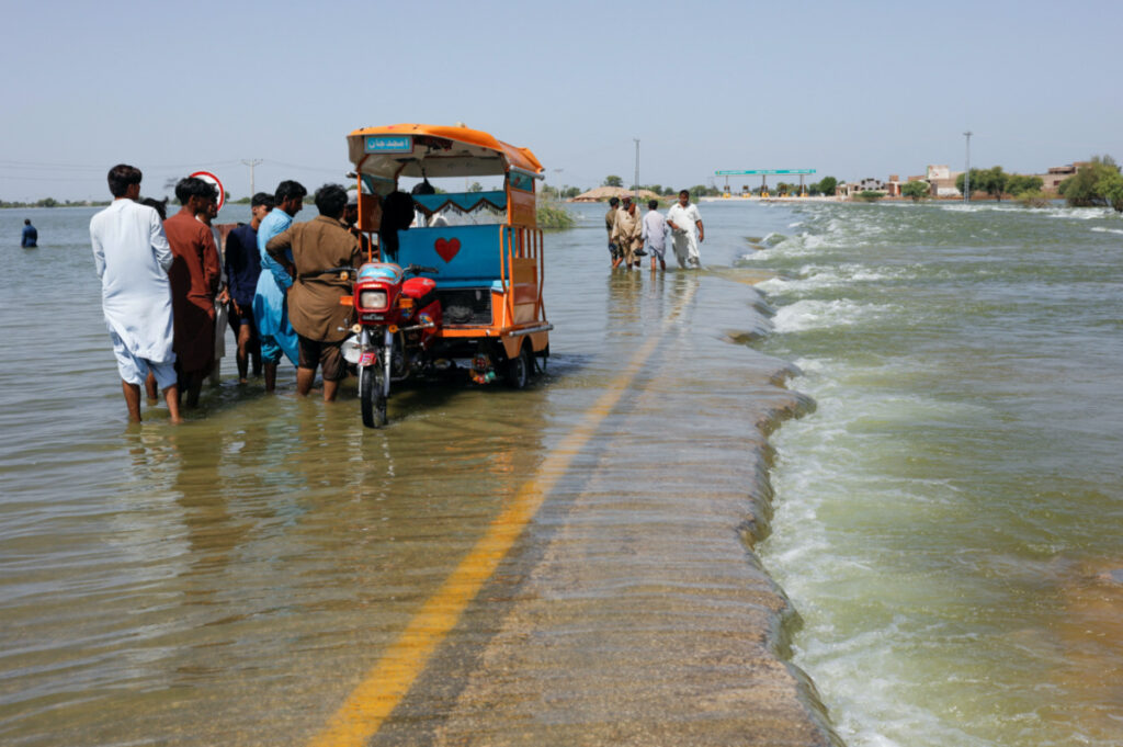 Displaced people stand on flooded highway, following rains and floods during the monsoon season in Sehwan, Pakistan, on 16th September, 2022