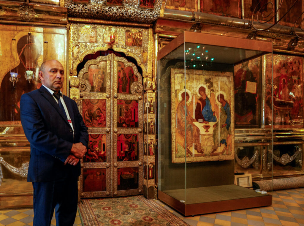 A security guard stands next to the Trinity icon at the Trinity Lavra of St. Sergius in the town of Sergiyev Posad, Russia, on 18th July, 2022.