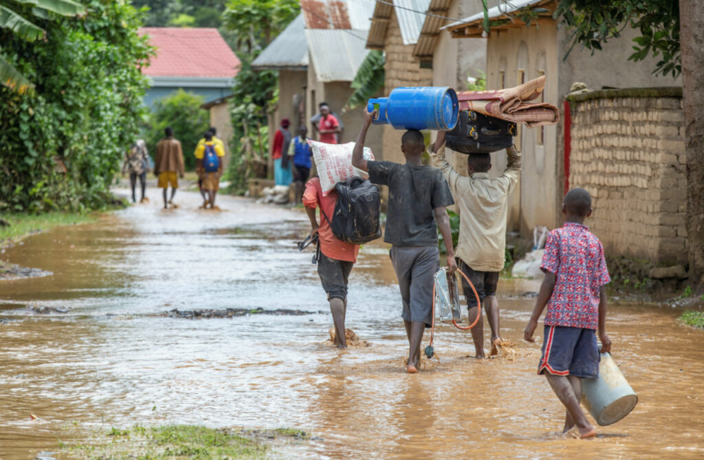 Residents wade through water after their homes were swamped following rains that triggered flooding and landslides in Rubavu district, Western province, Rwanda, on 3rd May, 2023