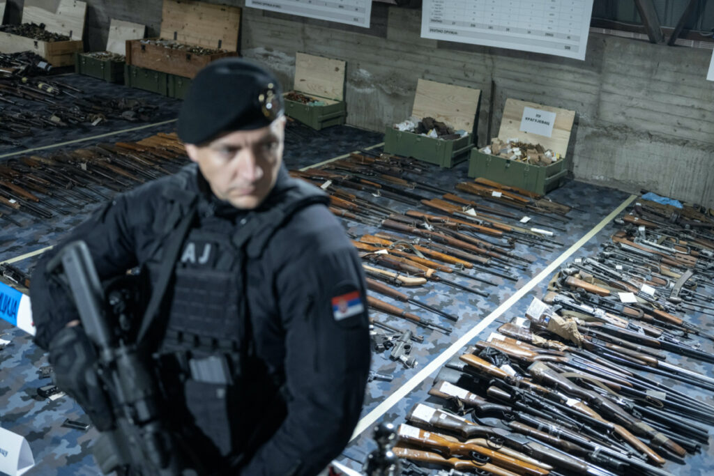 A police officer stands guard in front of the weapons handed over to police in the first ten days of gun amnesty in police storage following mass shootings in the country, near Smederevo, Serbia, on 14th May, 2023.