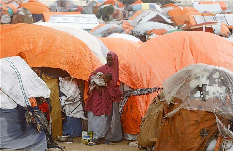 A Somali woman affected by the worsening drought due to failed rain seasons, stands outside her makeshift shelter at the Alla Futo camp for internally displaced people, in the outskirts of Mogadishu, Somalia, on 23rd September, 2022.
