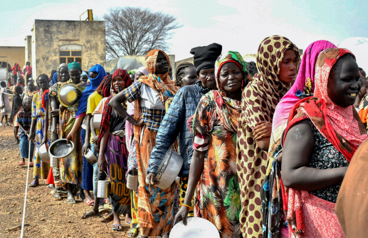 Women who fled the war-torn Sudan following the outbreak of fighting between the Sudanese army and the paramilitary Rapid Support Forces queue to receive food rations at the United Nations High Commissioner for Refugees transit centre in Renk, near the border crossing point in Renk County of Upper Nile State, South Sudan, on 1st May, 2023