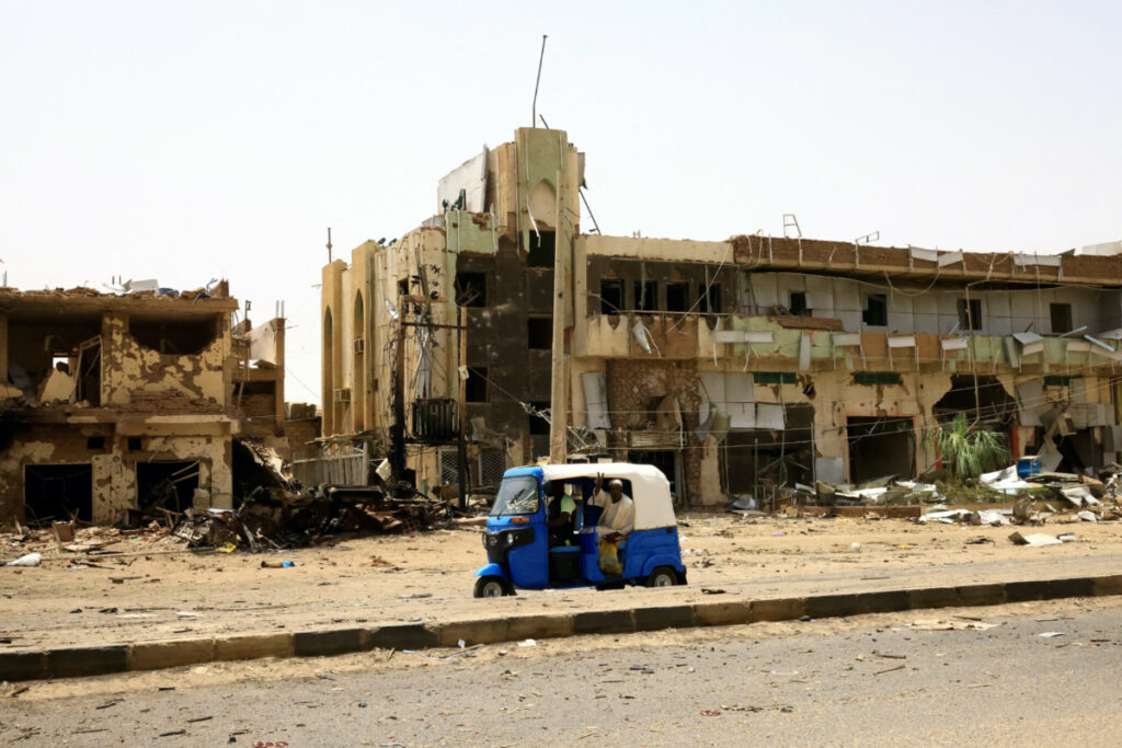 People pass by damaged cars and buildings at the central market during clashes between the paramilitary Rapid Support Forces and the army in Khartoum North, Sudan, on 27th April, 2023.