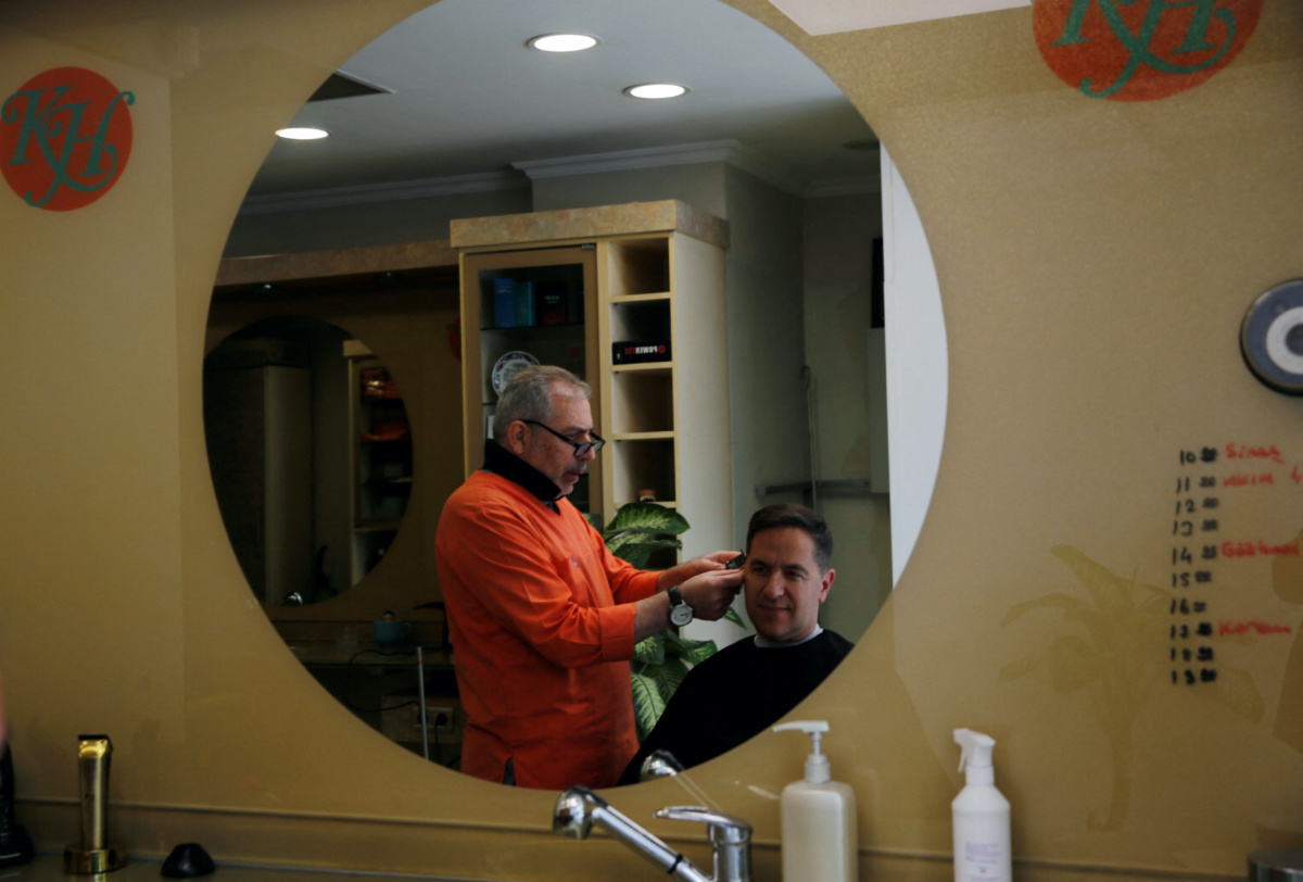 Barber Hakim Ekinci cuts his customer's hair at his shop in Istanbul, Turkey, on 4th May, 2023. 
