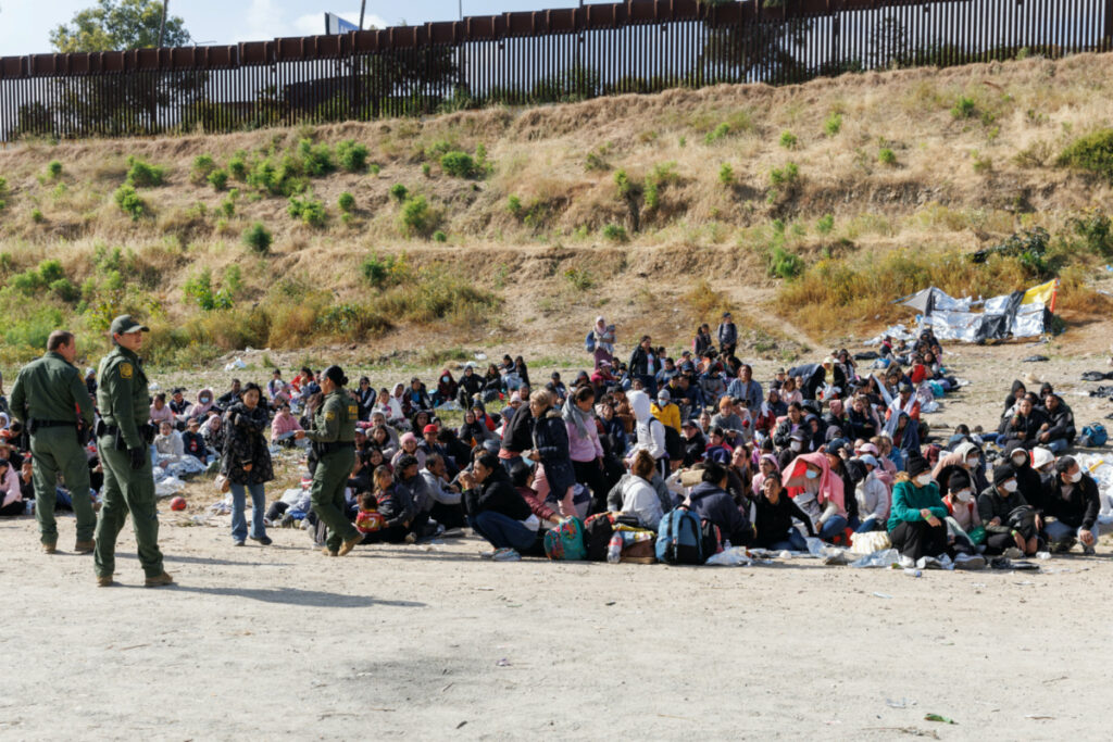US Border Patrol organize migrants after they gathered between primary and secondary border fences as the United States prepares to lift COVID-19 era Title 42 restrictions that have blocked migrants at the US-Mexico border from seeking asylum since 2020 near San Diego, California, US, on 9th May, 2023.